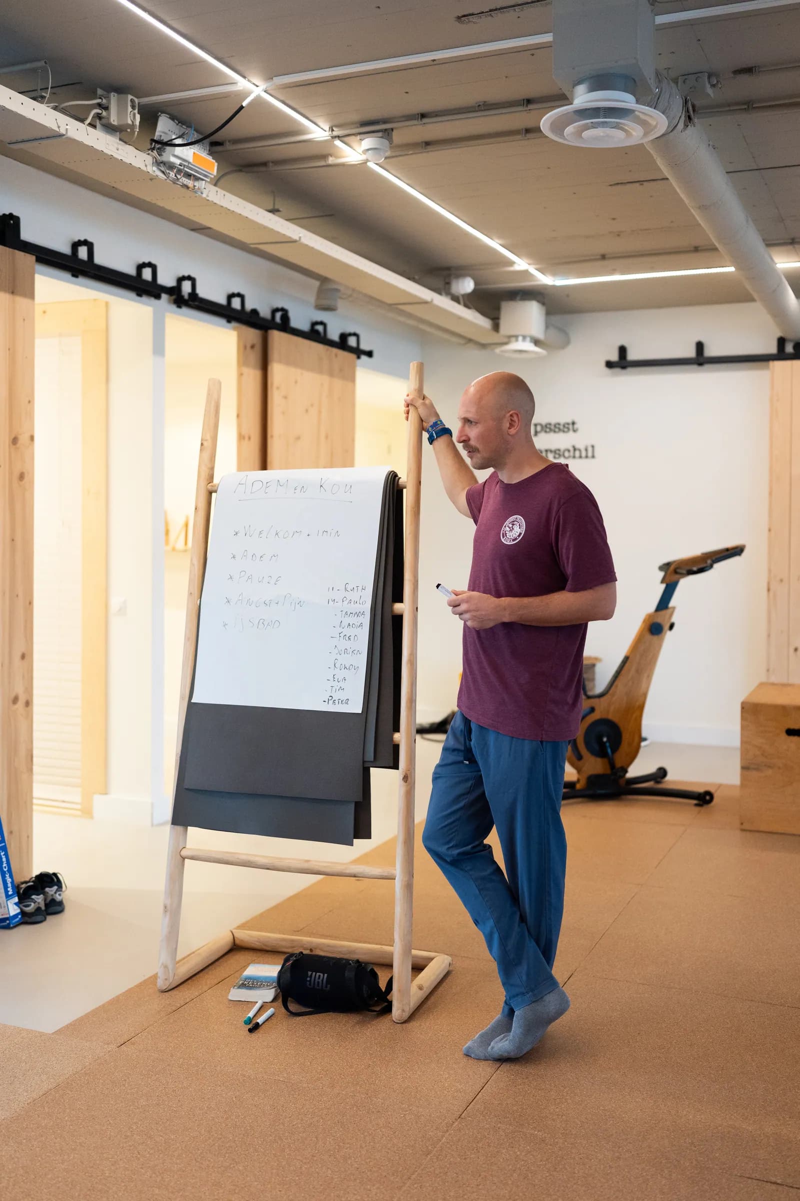 Coach bij flipover met notities over ademhaling naast roeiapparaat.